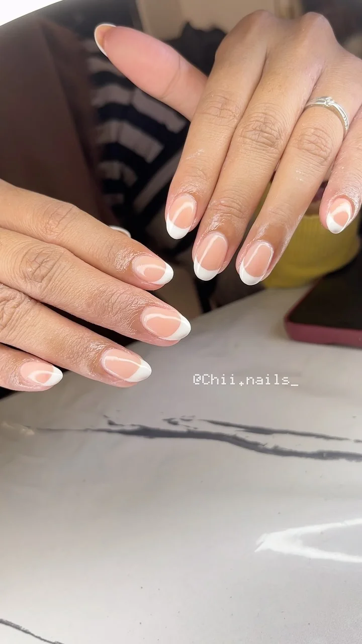 French manicure putih dengan detail garis melengkung