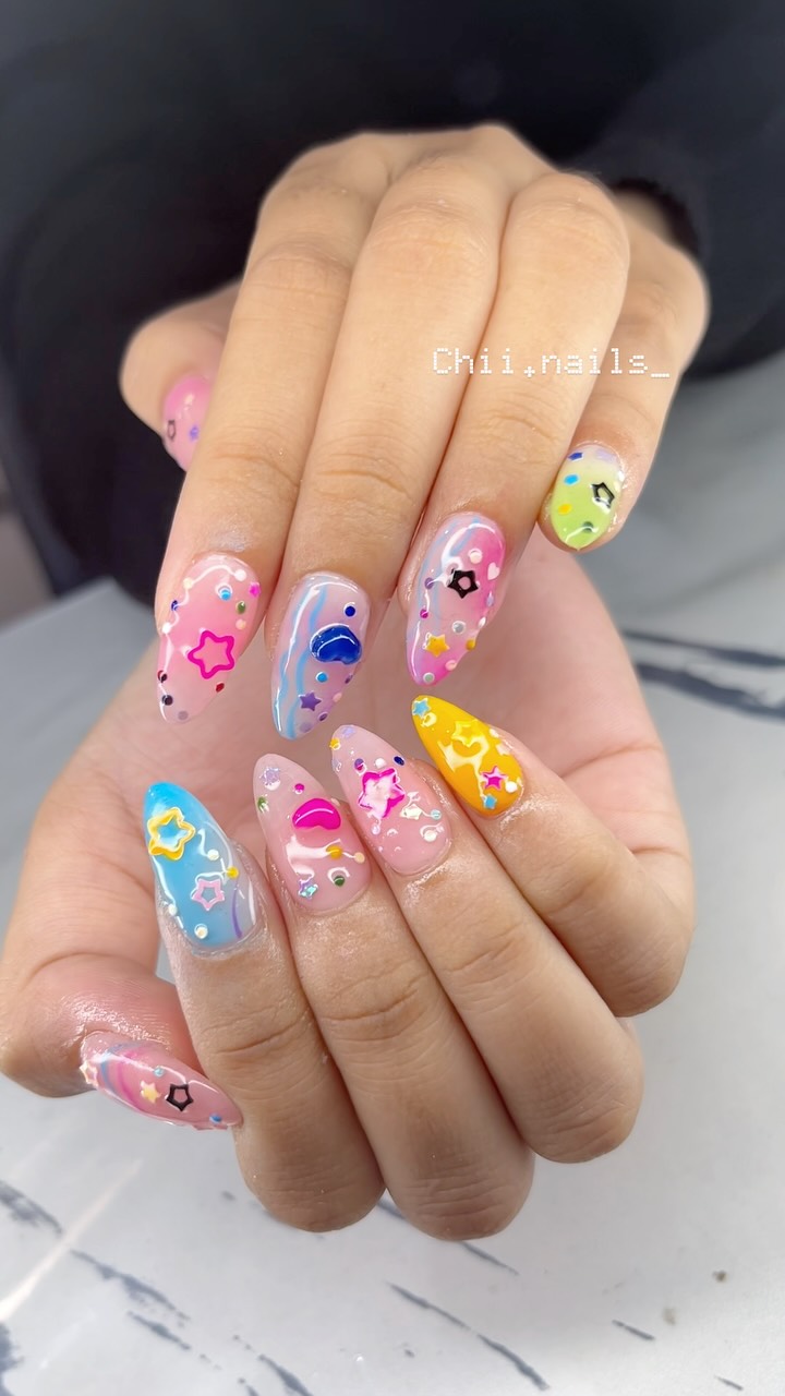 Nail art custom warna-warni dengan detail karakter dan bintang
